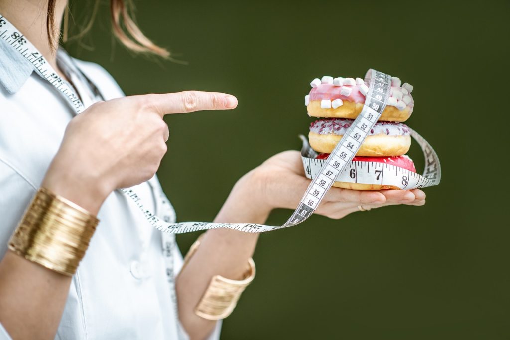 Kalori Cetveli: Besinlerin Kalori Listesi ve Günlük Kalori İhtiyacı Rehberi Nutritionist with unhealthy donuts
